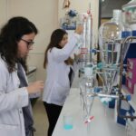 Scientists in a chemistry lab conducting experiments with precision.